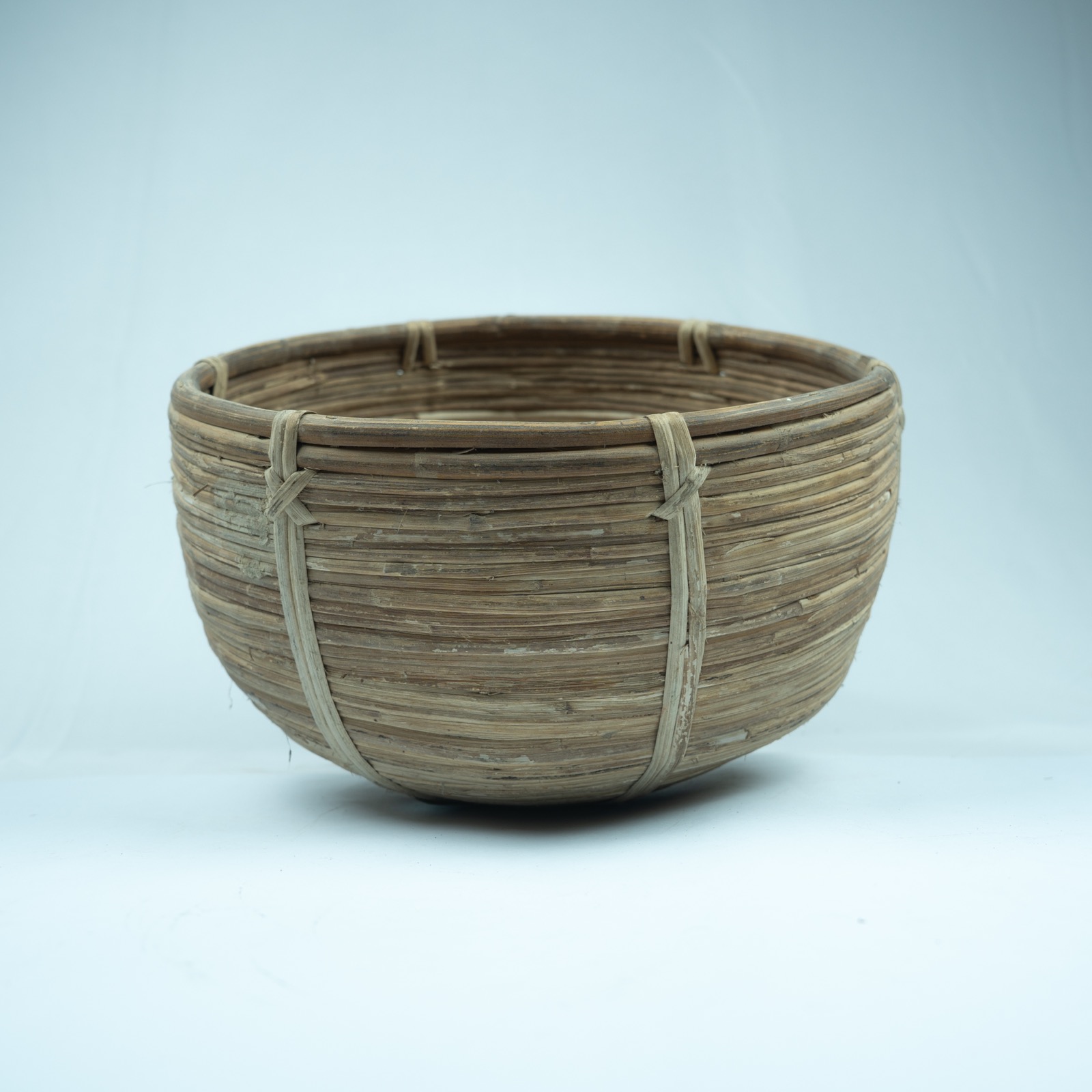 Product example: natural brown woven seagrass storage basket with round bowl shape, thick rim, horizontal weave and vertical wrapped rib details